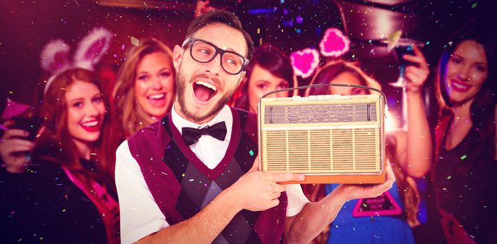 Geeky hipster holding a retro radio against pretty friends on a hen night