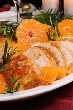 Slices of roasted chicken in tangerine sauce with rosemary