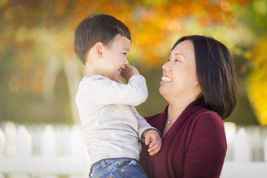 Happy Chinese Mom Having Fun and Holding Her Mixed Race Little Boy.