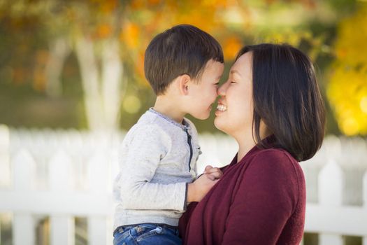 Happy Chinese Mom Having Fun and Holding Her Mixed Race Little Boy.