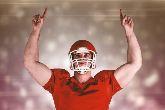 American football player cheering against black abstract light spot design