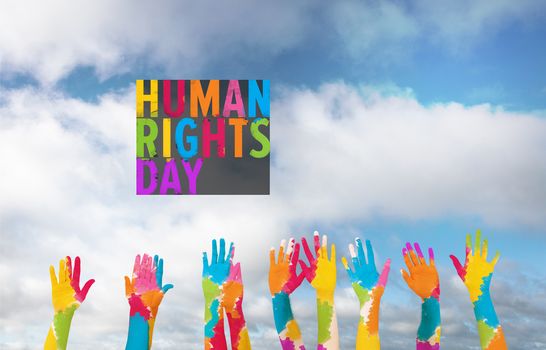 Group of people raising arms against scenic view of blue sky