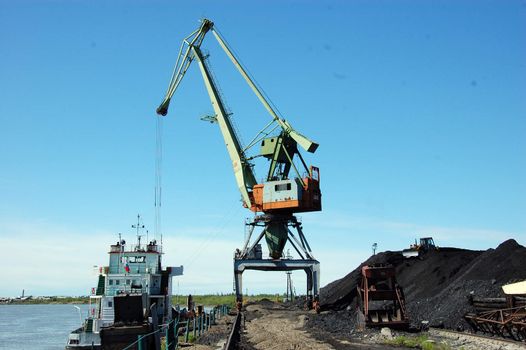 Dockside cargo crane at river port, Kolyma, Russia outback