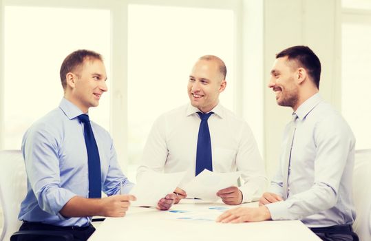 business and office concept - smiling businessmen with papers in office