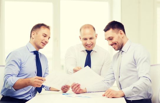 business and office concept - smiling businessmen with papers in office