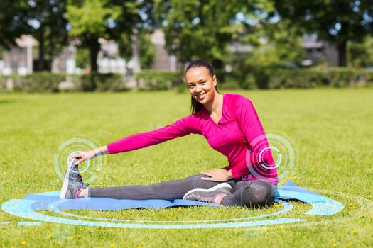 fitness, sport, training, park and lifestyle concept - smiling woman stretching leg on mat outdoors