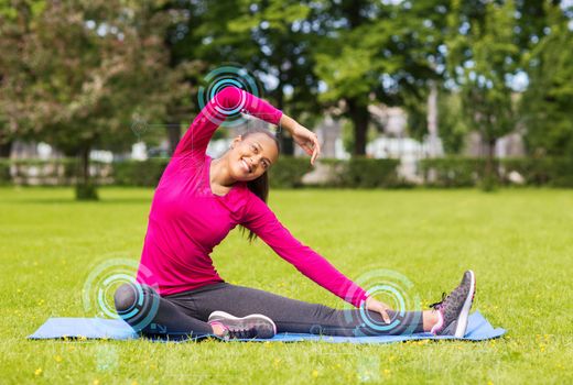 fitness, sport, training, park and lifestyle concept - smiling woman stretching leg on mat outdoors