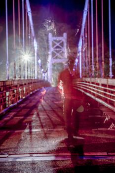 Non-descript ghostly male figure walking on bridge, defocused and texture applied