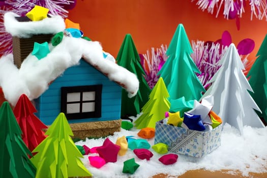 Small house and paper stars in a gift box on snow, with the Christmas tree