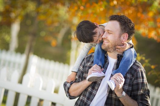 Happy Mixed Race Boy Riding Piggyback on Shoulders of Caucasian Father.