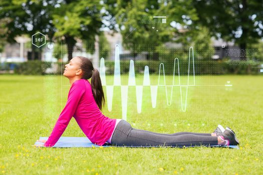 fitness, sport, training, park and lifestyle concept - smiling woman stretching back on mat outdoors