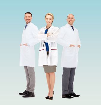 healthcare, profession and medicine concept - group of smiling doctors in white coats over blue background