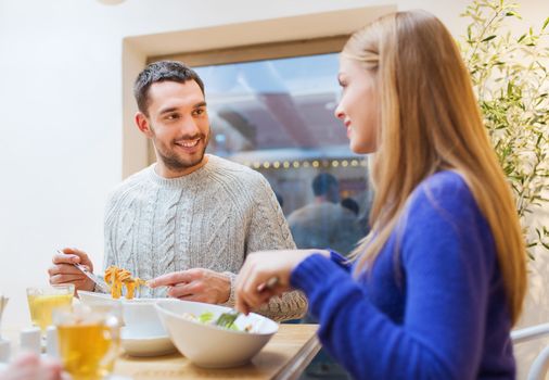 people, leisure, eating and communication concept - happy couple meeting and having dinner at cafe