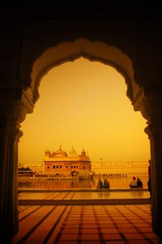 Amritsar Golden Temple, India. Framed with windows from west side in sunset. Focus on temple.