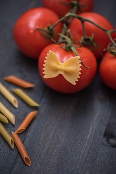 food background on rustic wood with pasta and tomatoes