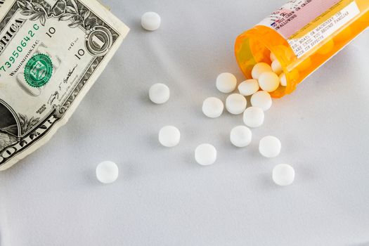 Pills on a white background with some money off to the side