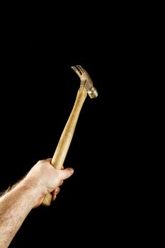Isolated against a black background a hammer is being swung