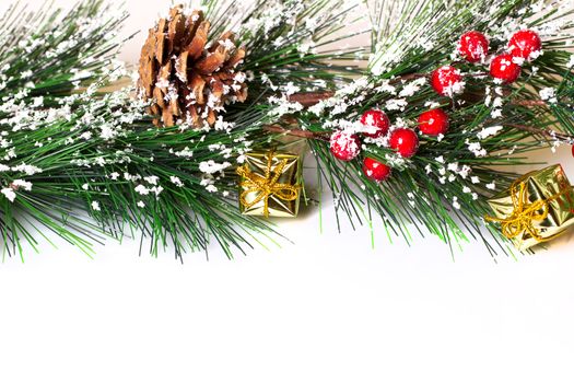 Pine branches with Christmas ornaments on white