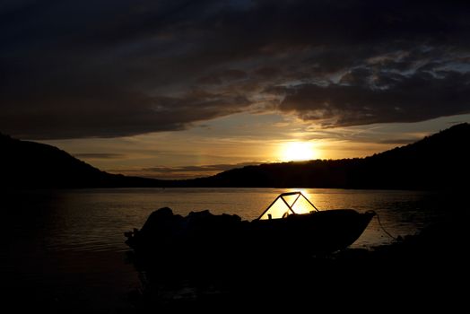 River at sunset with boat moored near the shore.