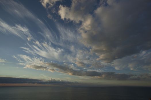 Panorama of clouds against the blue sky over the sea.