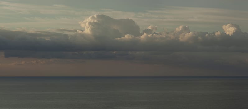 Panorama of clouds against the blue sky over the sea.