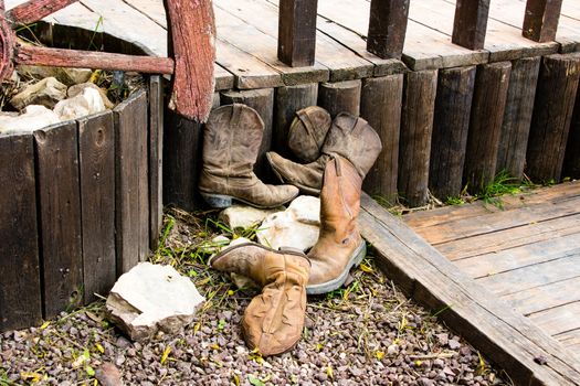 The old cowboy boots thrown in the corner near the entrance to the stables