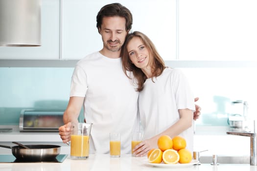 Couple with orange juice in the kitchen