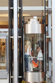 Group of women in transparent elevator at shopping mall