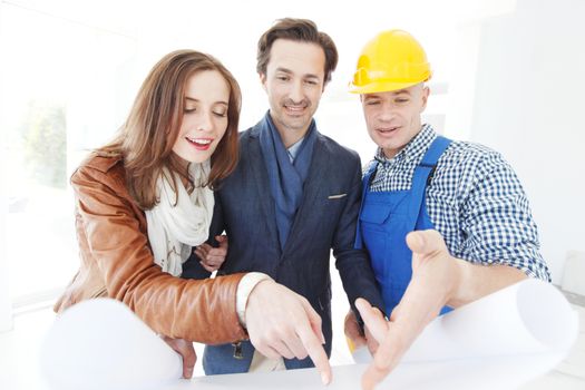 Foreman shows house design plans to a young couple