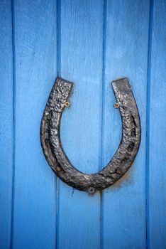 black horseshoe on a blue wooden door