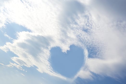 blue sky love heart among white fluffy clouds