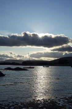 boats in a quiet bay near kenmare on the wild atlantic way ireland with a cold blue sunset