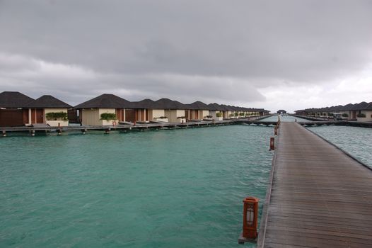Timber pier and bungalow at Paradise Island Resort Maldives, Indian Ocean