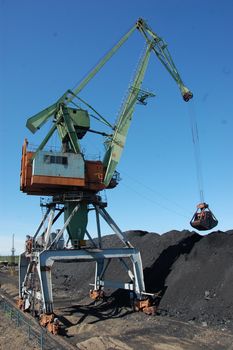 Dockside cargo crane uploads coal at Kolyma port, Russia