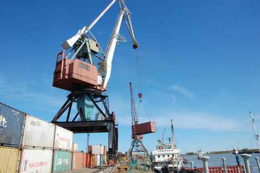 Dockside cargo crane with container at river port, Kolyma, Russia