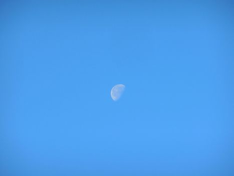 Earth's Moon day on the clear blue sky.