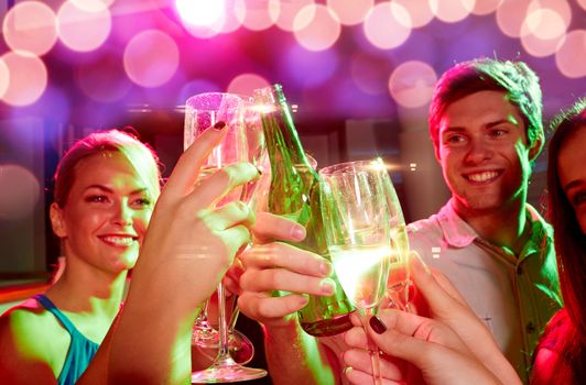 party, holidays, celebration, nightlife and people concept - smiling friends clinking glasses of champagne and beer in club