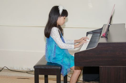 asian child playing the piano