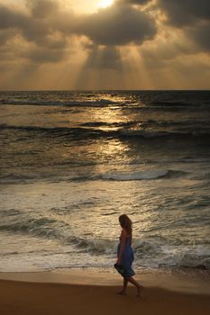 The lonely girl on a beach on sunset