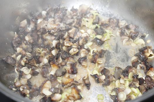 Closeup of eating the fried snails with stalks lemon grass 