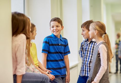 education, elementary school, children, break and people concept - group of smiling school kids talking in corridor