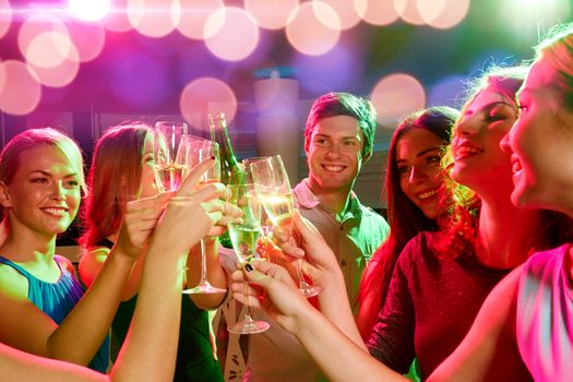 party, holidays, celebration, nightlife and people concept - smiling friends clinking glasses of champagne and beer in club