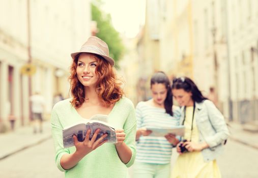 tourism, travel, holidays and friendship concept - smiling teenage girls with city guide, map and camera outdoors