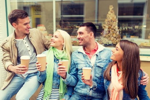 friendship, travel, drink and vacation concept - group of smiling friends with take away coffee