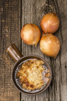 A bowl of rustic homemade french onion soup photographed from overhead.