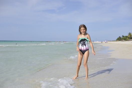 Girl on the Caribbean sunny beach with white sand.