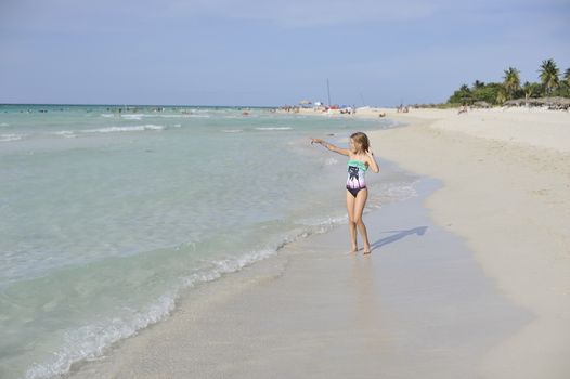 Girl on the Caribbean sunny beach with white sand.