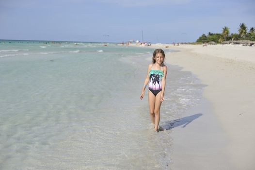 Girl on the Caribbean sunny beach with white sand.