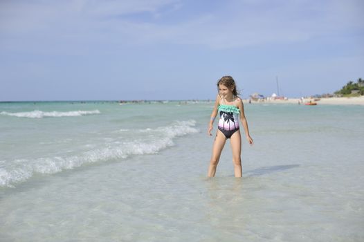 Girl on the Caribbean sunny beach with white sand.