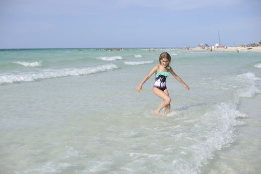 Girl on the Caribbean sunny beach with white sand.